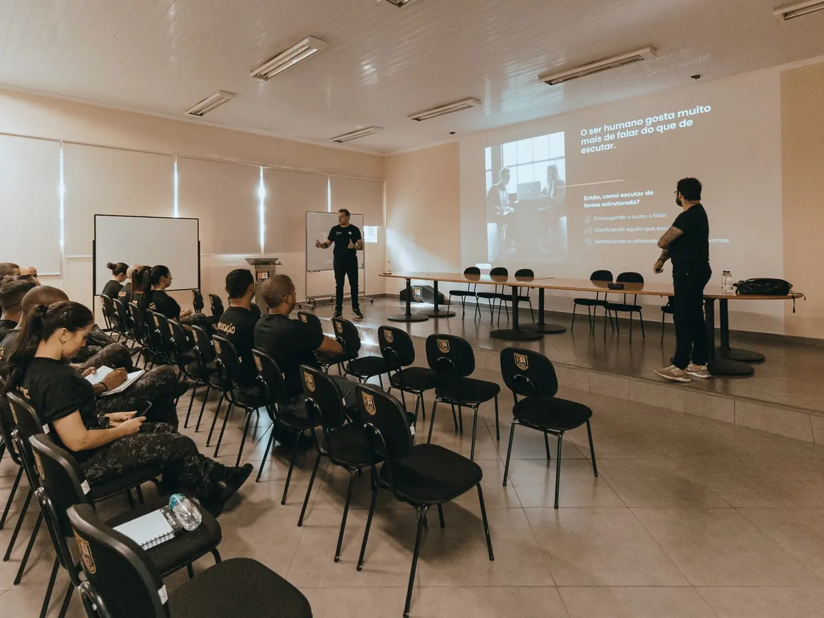 Facilitação de uma sessão de treinamento com o grupo tomando notas.