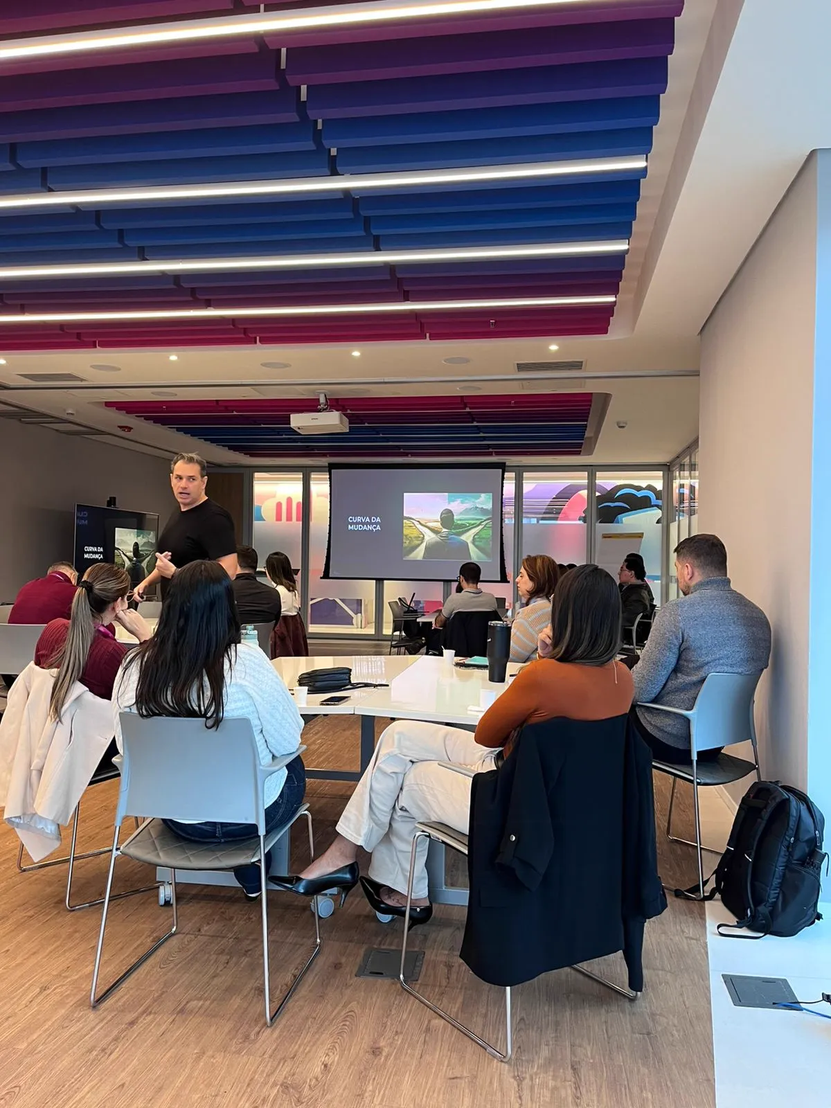 Sala de treinamento durante uma sessão em execução, com participantes acompanhando a facilitação.